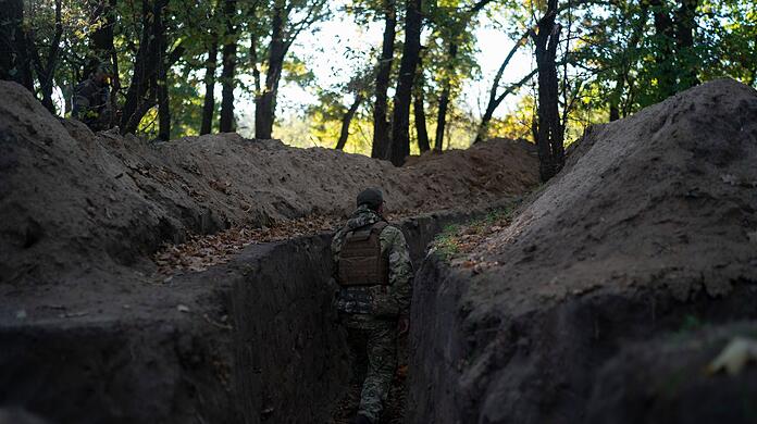 Ein ukrainischer Soldat überprüft die von russischen Soldaten ausgehobenen Schützengräben.
