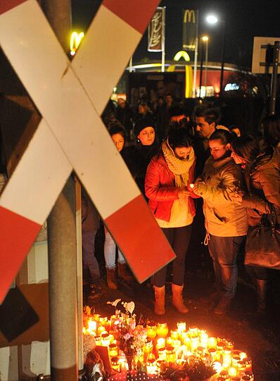 Menschen trauern n Günzburg an einem Bahnübergang. Aus unbekannter Ursache waren dort am 27.12.2012 zwei Mädchen von einem Zug erfasst und getötet worden.