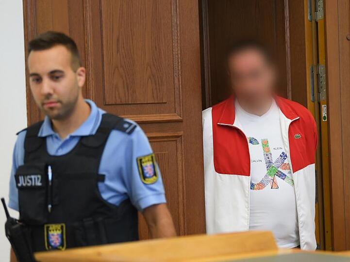 Der 48-jährige Angeklagte kommt in Begleitung eines Justizbeamten zum Prozessbeginn in den Gerichtssaal. Foto: Arne Dedert