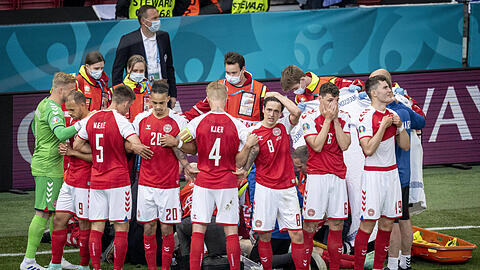 Sichtwall: Die dänischen Teamkollegen blocken die Blicke auf Christian Eriksen ab, der während des EM-Spiels gegen Finnland nach einem Herzstillstand von den Ärzten wiederbelebt wird.