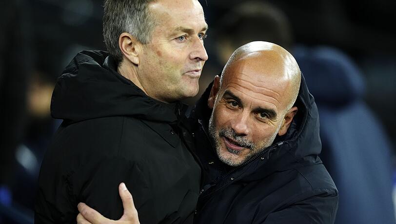 Manchester Citys Trainer Pep Guardiola (r) umarmt Bayer Leverkusens Cheftrainer Kasper Hjulmand vor dem Spiel.