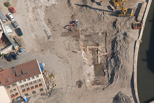 Noch suchen die Archäologen im Untergrund des Augustinerhofs nach Spuren von Nürnbergs Siedlungsgeschichte. Ende September sollen die Grabungen beendet sein. Bevor mit dem Bau des 60 Millionen-Projekts begonnen wird, wird das Areal zwischen Hauptmarkt und Pegnitz (rechts im Bild) als Parkplatz zwischengenutzt.
