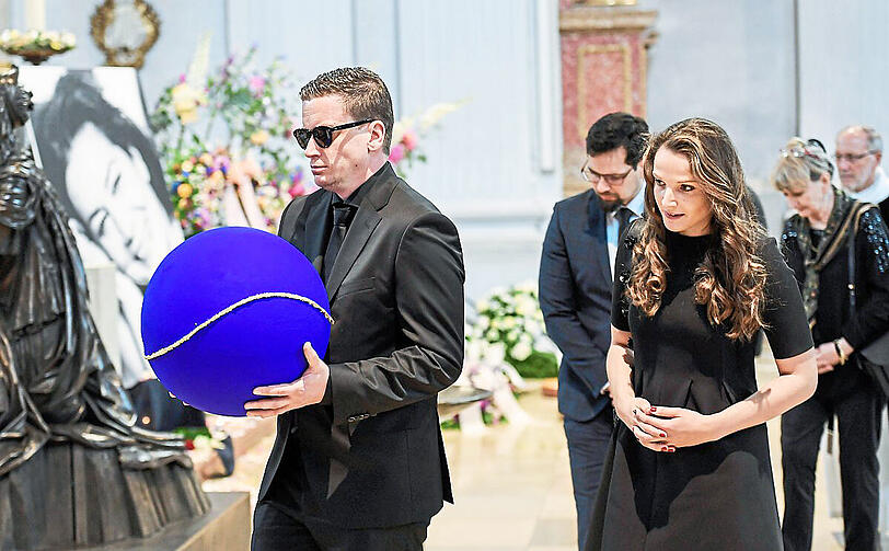 Elsners Sohn Dominik Elstner trägt die Urne, die eine Weltkugel symbolisiert. Neben ihm Freundin Michele Werner.