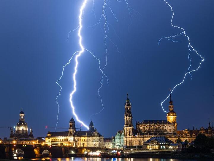 Blitze schlagen während eines Gewitters am Abend in die historische Altstadtkulisse von Dresden mit der Frauenkirche (l-r), dem Ständehaus, der Hofkirche und dem Hausmannsturm ein.
