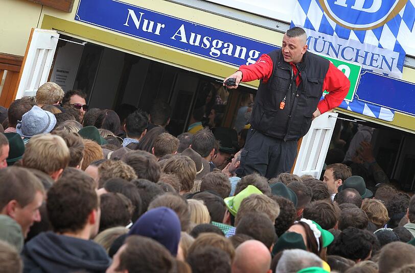 Ein Ordner kontrolliert den Ansturm auf ein Oktoberfest-Zelt.