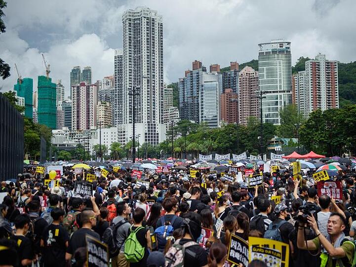 Teilnehmer einer Demonstration kommen zur Protestkundgebung im Victoria Park.