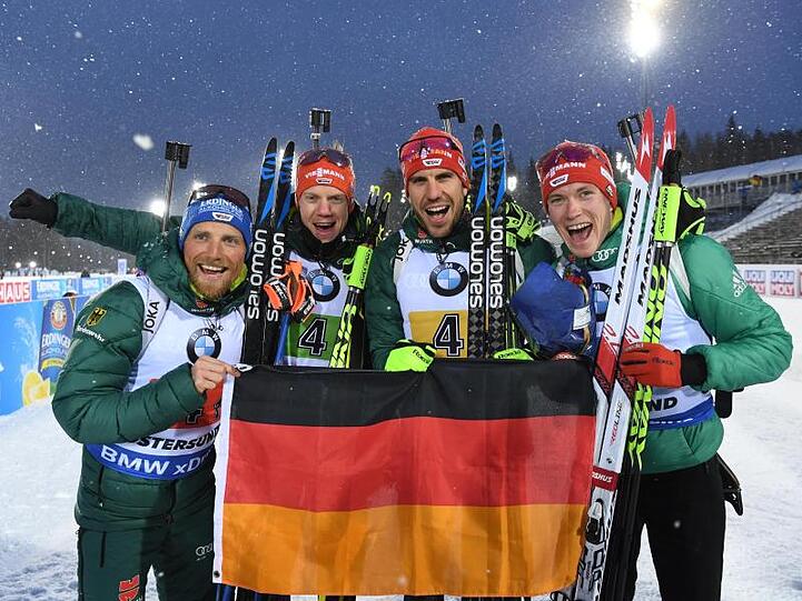 Erik Lesser (l-r-), Roman Rees, Arnd Peiffer und Benedikt Doll freuen sich mit einer deutschen Fahne über den zweiten Platz.