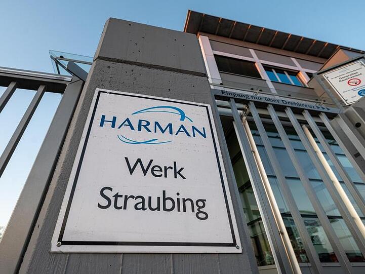 "Harman - Werk Straubing" steht vor dem Werk des Autozulieferers. Foto: Armin Weigel/dpa/Archivbild