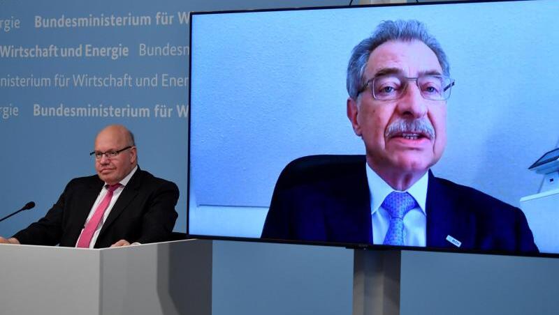 Bundeswirtschaftsminister Peter Altmaier (l) sitzt neben einer Leinwand, auf der BDI-Präsident Dieter Kempf zu sehen ist. Bundeswirtschaftsminister Peter Altmaier (l) sitzt neben einer Leinwand, auf der BDI-Präsident Dieter Kempf zu sehen ist.