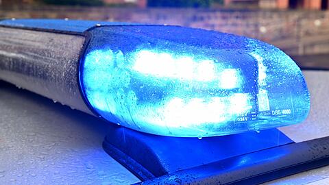 Ein Streifenwagen der Polizei steht mit eingeschaltetem Blaulicht.