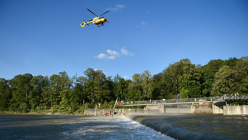 Helfer retten mit Hilfe eines Hubschraubers an der Marienklausenbrücke einen Mann aus der Wasserwalze am Wehr.
