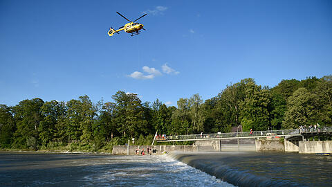 Helfer retten mit Hilfe eines Hubschraubers an der Marienklausenbrücke einen Mann aus der Wasserwalze am Wehr.