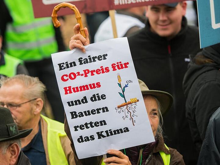 Ein Landwirtin hält während einer Kundgebung ein Plakat. Foto: Andreas Arnold/dpa/Archiv