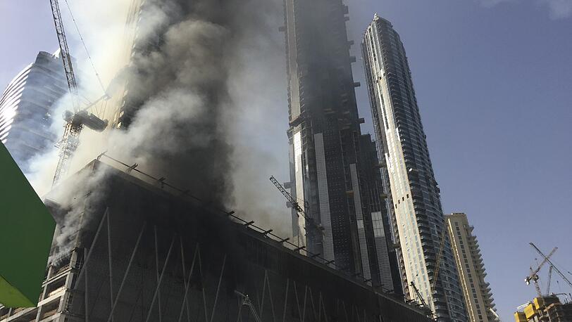 Dichte Rauchschwaden steigen in Dubai aus einem im Bau befindlichen Hochhaus auf. Riesige schwarze Rauchwolken sind über die Stadt zu sehen.