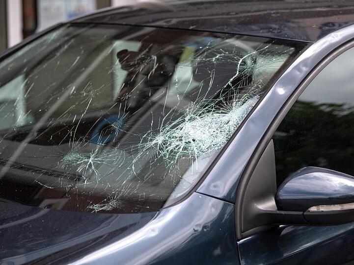 Die Frontscheibe eines Autos ist durch ein Unwetter beschädigt. Foto: Sina Schuldt/Archivbild