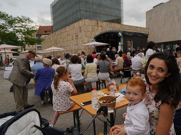 Entspannte Stimmung herrscht im beim jüdischen Fest im Publikum vor der Synagoge. Auch viele Kinder sind dabei.