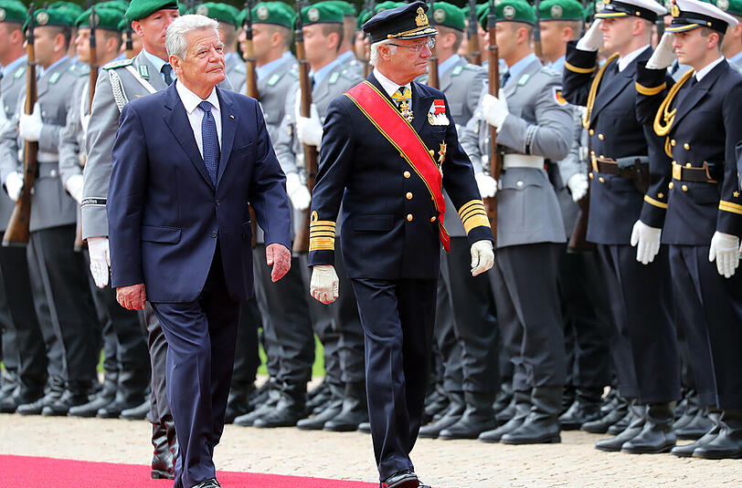 In Uniform schreitet König Carl Gustaf die Ehrengarde der Bundeswehr ab.