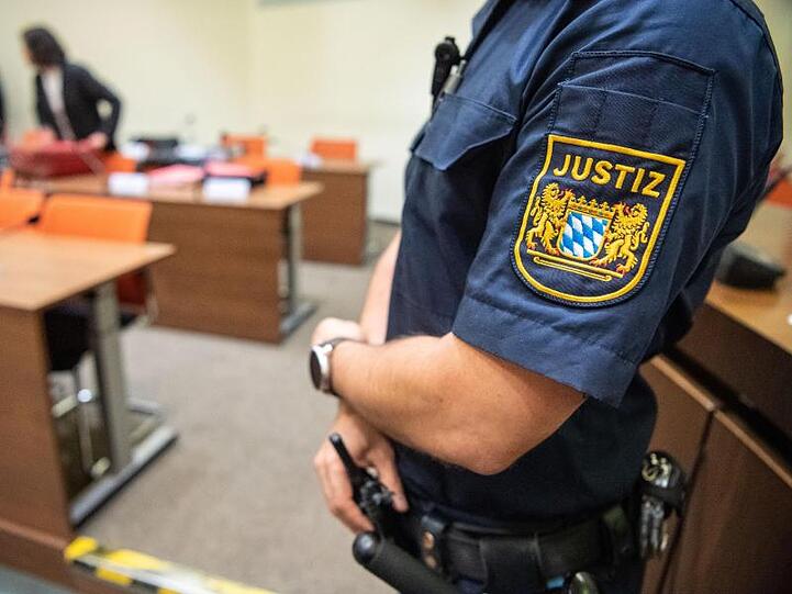 Ein Justizbeamter steht zu Beginn des Prozesses im Sitzungssaal vom Landgericht München. Foto: Lino Mirgeler/Archiv