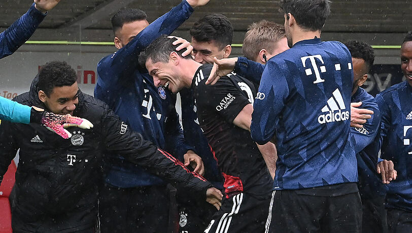 Robert Lewandowski wird nach seinem historischen Treffer von den Teamkollegen bejubelt.