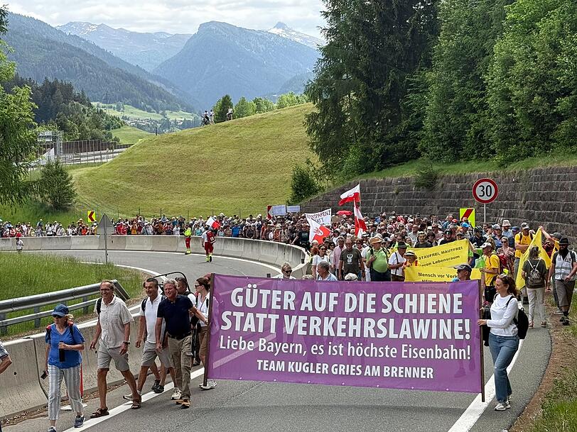 Matrei am Brenner: Teilnehmer der Demonstration protestieren mit Bannern und Plakaten gegen die Verkehrsflut am Brenner.
