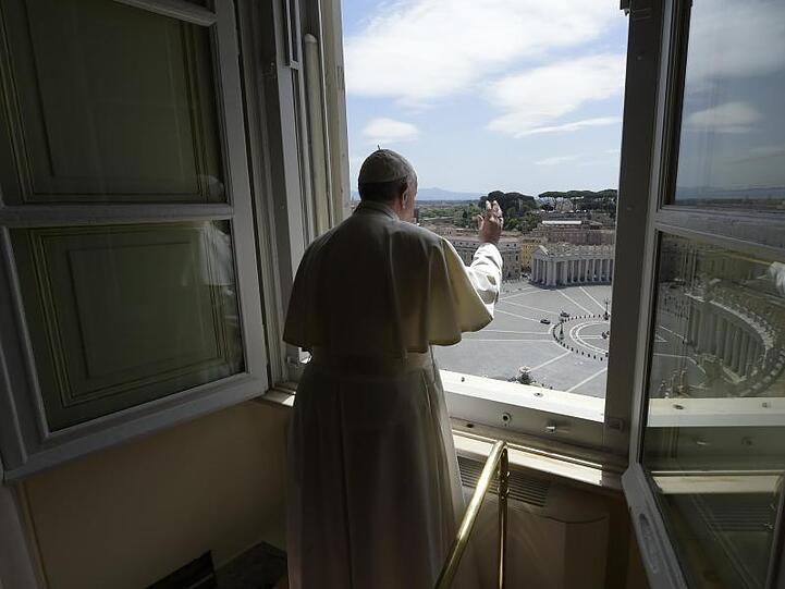 Papst Franziskus erteilt aus dem Fenster seinen Segen mit Blick auf den Petersplatz, der aufgrund der Anti-Corona-Maßnahmen menschenleer ist.