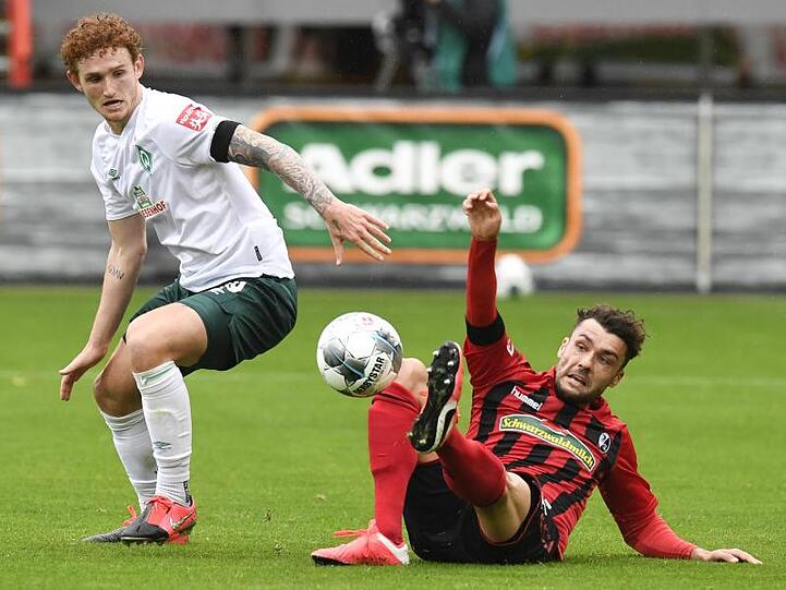 Freiburgs Manuel Gulde (r) im Zweikampf mit Bremens Josh Sargent um den Ball.