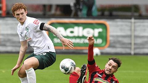 Freiburgs Manuel Gulde (r) im Zweikampf mit Bremens Josh Sargent um den Ball.