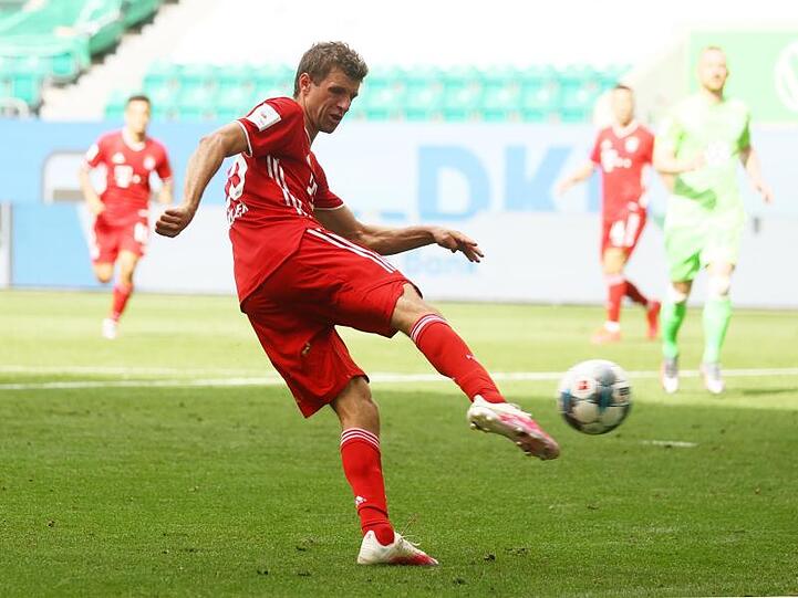 Thomas Müller von Bayern schießt beim Spiel gegen Wolfsburg das Tor zum 4:0. Foto: Kai Pfaffenbach/Reuters-Pool/dpa