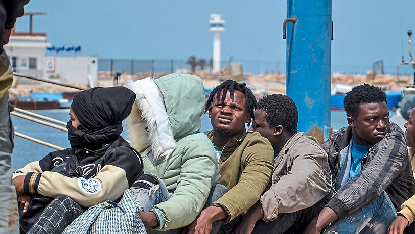 Subsaharische Migranten, die von der tunesischen Marine-Nationalgarde im Mittelmeer abgefangen wurden, warten im Hafen von Sfax.