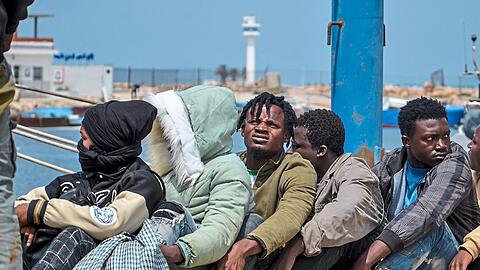 Subsaharische Migranten, die von der tunesischen Marine-Nationalgarde im Mittelmeer abgefangen wurden, warten im Hafen von Sfax.