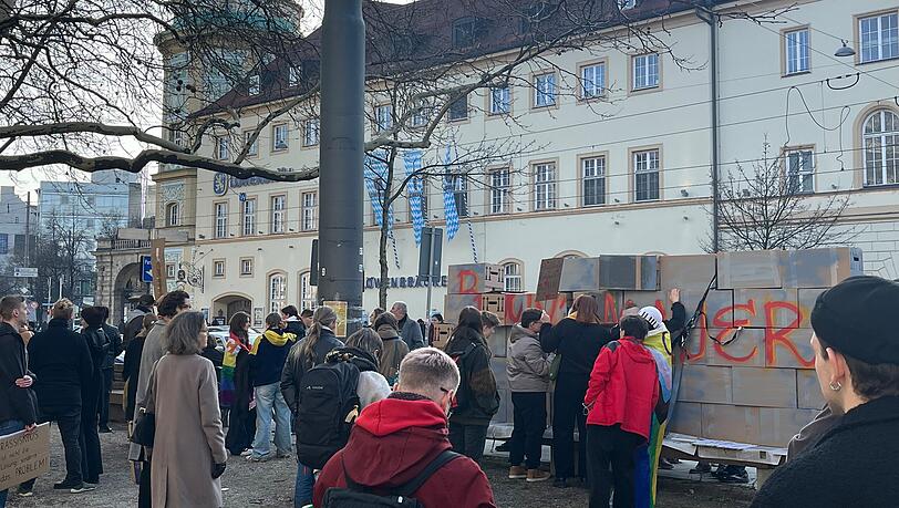Demonstranten rissen gegenüber dem Löwenbräukeller eine symbolische Brandmauer ein. Merz hielt dort eine Wahlkampfveranstaltung.