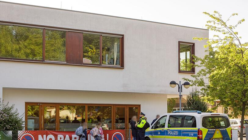 Die Polizei steht vor einer Grundschule im Berliner Bezirk Spandau, während Schüler am Morgen zur Schule kommen.