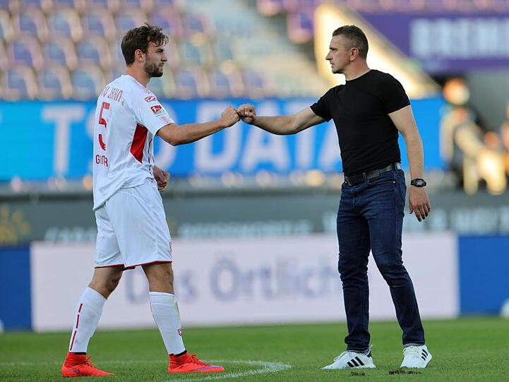 Regensburgs Benedikt Gimber (l.) und Trainer Mersad Selimbegovic klatschen nach dem Spiel ab. Foto: Friedemann Vogel/epa/Pool/dpa