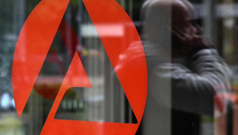 Ein Mann spiegelt sich in München im verglasten Eingangsbereich der Agentur für Arbeit. Ein Mann spiegelt sich in München im verglasten Eingangsbereich der Agentur für Arbeit.