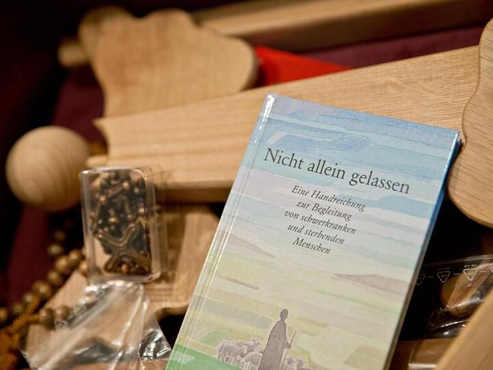 Ein Buch, ein Engel aus Holz und ein Rosenkranz sind im Hospiz des Juliusspitals in Würzburg zu sehen. Foto: Daniel Karmann/Archiv