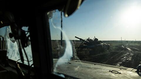 Ein zerstörter Panzer ist durch das Fenster eines Fahrzeugs an der Frontlinie in der Nähe von Klischtschijiwka bei Bachmut zu sehen.