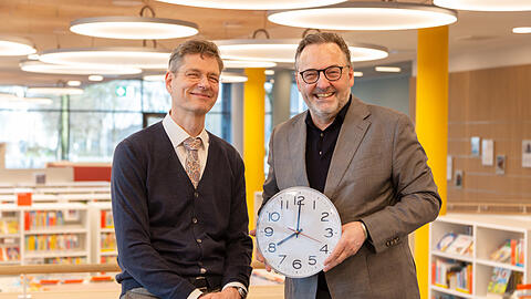 Arne Ackermann, Direktor der Münchner Stadtbibliothek, und Kulturreferent Anton Biebl (v. l.) feiern die erweiterten Öffnungszeiten in der Stadtbibliothek Riem.