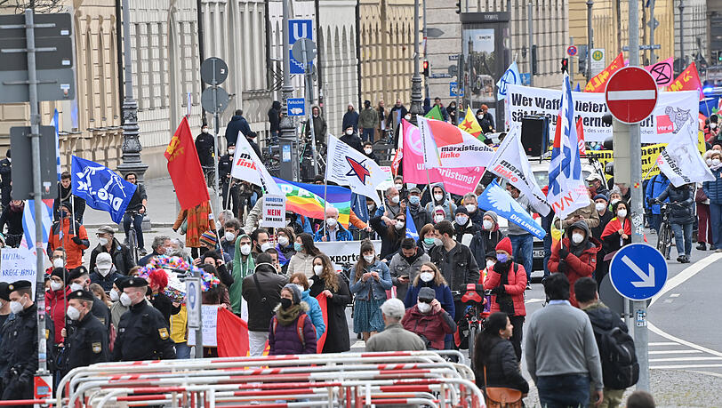 Teilnehmer gehen beim Ostermarsch mit Bannern, Fahnen und Plakaten durch die Münchner Innenstadt.