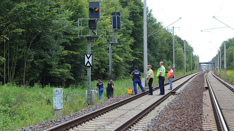 Mitarbeiter der Bahn und der Polizei untersuchen eine Signalanlage bei Berlin. Unbekannte hatten sie in Brand gesetzt.