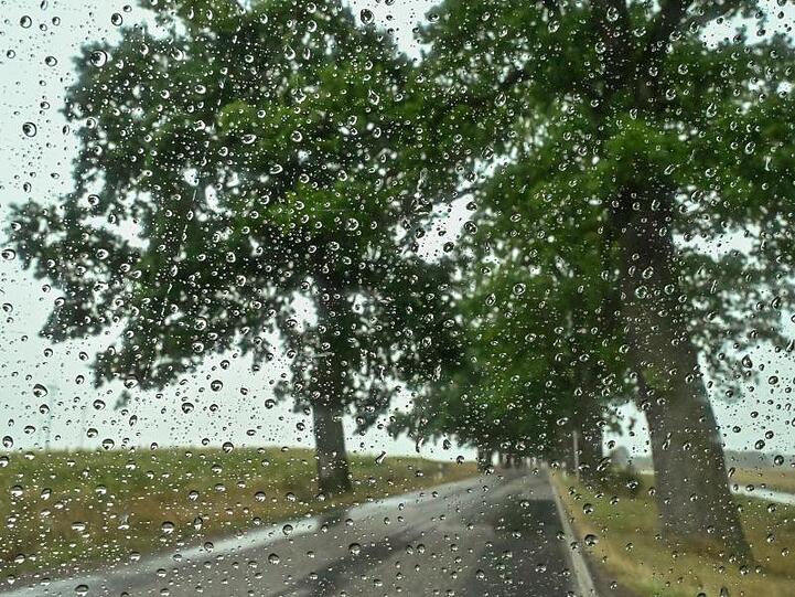 Regentropfen sind an einer Scheibe eines Autos zu sehen. Nach vielen Tagen mit Hitze und Trockenheit bringt ein Regengebiet Abkühlung und Niederschläge.