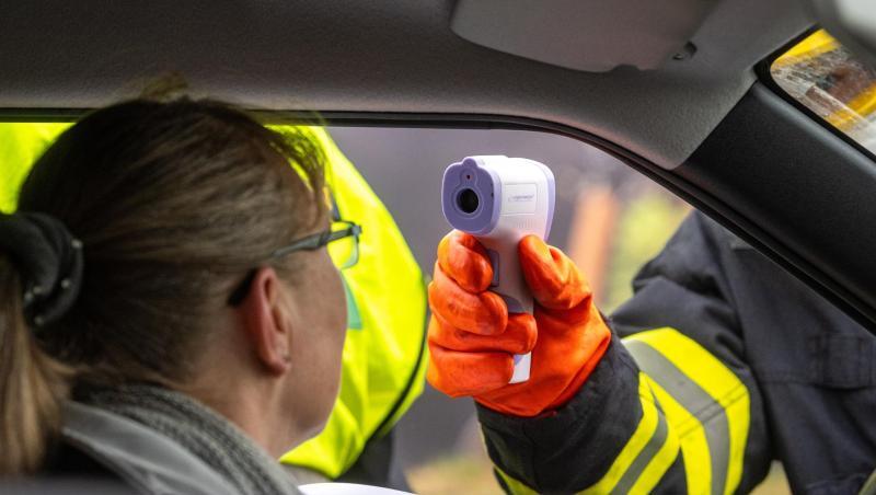 Ein Feuerwehrmann aus Tschechien misst and der Grenze die Temperatur von einer Einreisenden. Foto: Armin Weigel/dpa Ein Feuerwehrmann aus Tschechien misst and der Grenze die Temperatur von einer Einreisenden. Foto: Armin Weigel/dpa