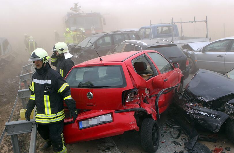 Feuerwehrleute sind am Freitag auf der Autobahn A19 bei Kavelstorf in der Nähe von Rostock bei einer Massenkarambolage im Einsatz. Bei einem Sandsturm fuhren in beiden Fahrtrichtungen Dutzende Fahrzeuge und LKW ineinander und brannten teilweise aus.