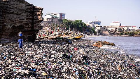 Ein Sandstrand, dessen Sand gar nicht mehr zu sehen ist: Massen an Klamotten vermüllen diesen Küstenabschnitt von Accra.