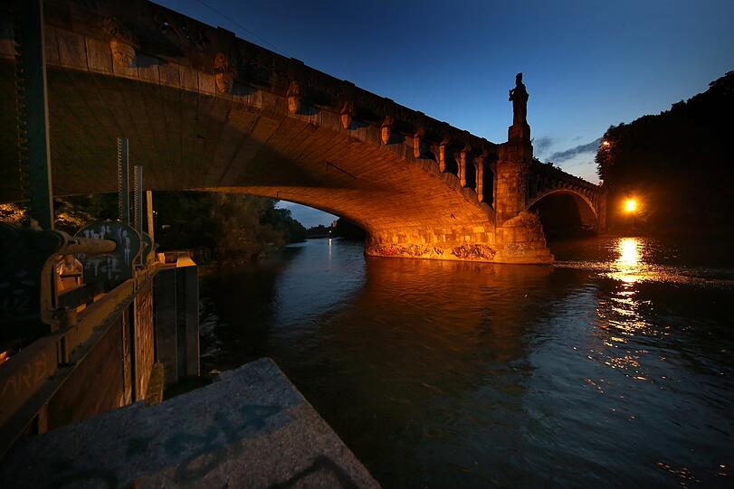 Nicht nur oben, auch unten am Fluss eine Schau: die festlich angestrahlte Maximiliansbrücke.