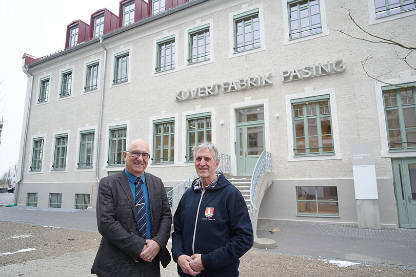 Haupteingang der Kuvertfabrik mit dem historischen Schriftzug: Pasings BA-Chef Frieder Vogelsgesang (CSU, l.) und Thomas Hasselwander vom Pasinger Archiv.