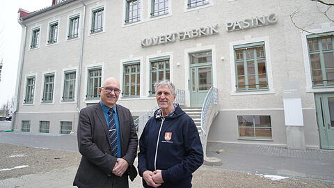 Haupteingang der Kuvertfabrik mit dem historischen Schriftzug: Pasings BA-Chef Frieder Vogelsgesang (CSU, l.) und Thomas Hasselwander vom Pasinger Archiv.