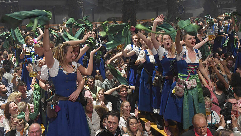 Bedienungen im Hofbräu-Festzelt tanzen und feiern beim Wiesn-Kehraus auf den Tischen.