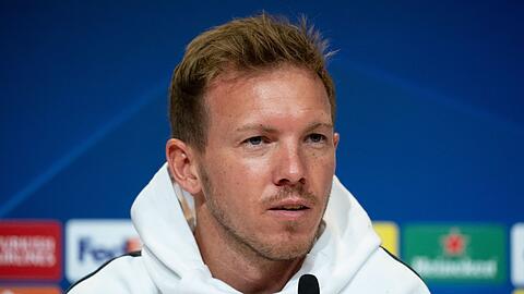 Bayern-Trainer Julian Nagelsmann sitzt während der Pressekonferenz auf dem Podium.