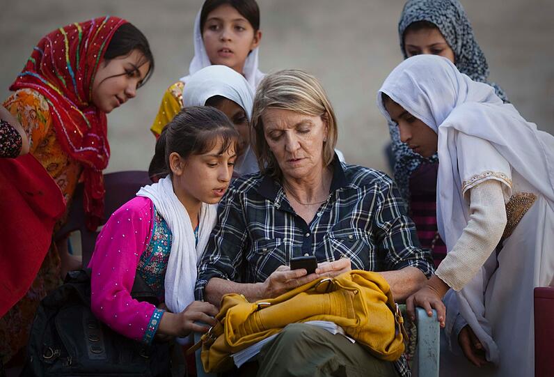 Ein Foto aus dem Jahr 2011 zeigt die AP-Korrespondetin Kathy Gannon in einer Schule in Kandahar zusammen mit afghanischen Mädchen. Sie saß mit Anja Niedringhaus im Auto als die Schüsse fielen und wurde schwer verletzt.