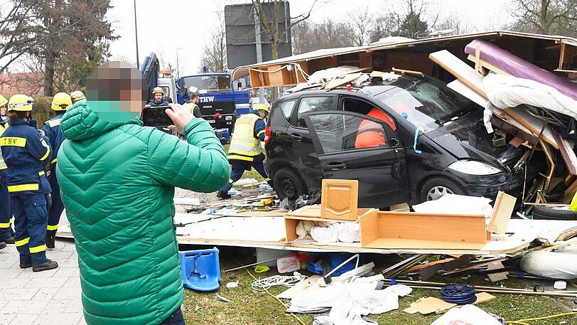 Der Besitzer des Wohnwagens (grüne Jacke) sammelt seine Habseligkeiten zusammen.